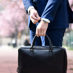 Labor Market Explorer for Students. A person holding a briefcase while straightening a jacket cuff. Photo Credit: Andrea Natali on Unsplash [https://unsplash.com/photos/jdTtkmr1axk]