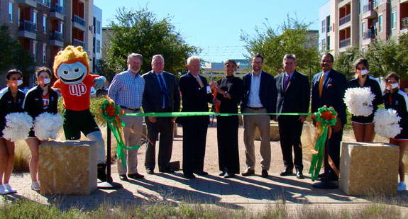 Northside at UT Dallas. A group of officials standing in the main spine of Northside, preparinging to cut a ribbon.