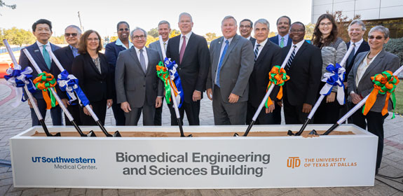 The construction site for the Texas Instruments Biomedical Engineering and Science Building. A group of officials standing before a set of shovels prepares to symbolically break ground on the project.