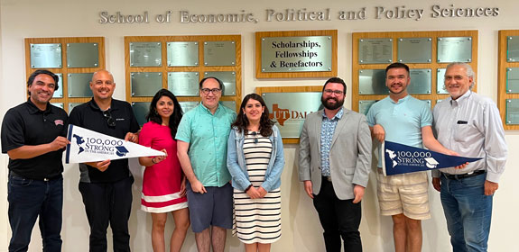 A group of students and presenters standing in front of the School of Economic, Political and Policy Science.