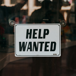 DFW Labor Market Update. A “Help Wanted” Sign. Photo Credit: Nathan Dumlao on Unsplash [https://unsplash.com/photos/xRb4O75uymo]