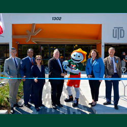 A ribbon-cutting. From left: Dr. Rafael Martín, vice president and chief of staff; Dr. Calvin Jamison, vice president for Facilities & Economic Development; Dr. Inga Musselman, vice president for Academic Affairs and provost; Dr. Richard C. Benson, president and Eugene McDermott Distinguished University Chair of Leadership; Temoc, University mascot; Amanda Oneacre Rockow, vice president for Public Affairs; Dr. Joseph J. Pancrazio, vice president for Research and Innovation.