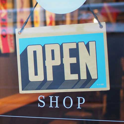 DFW Labor Market Update. A shop window sign turned to the “OPEN” side. Photo Credit: Mike Petrucci on Unsplash [https://unsplash.com/photos/gray-and-blue-open-signage-c9FQyqIECds]