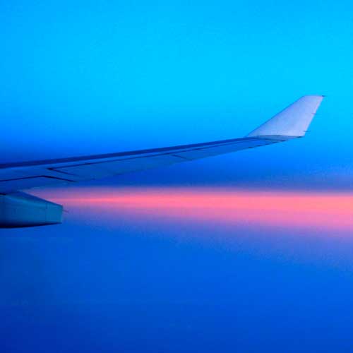 The wing of a plane in flight seen at sunset. Photo Credit: CC BY 2.0 2008 rumpleteaser [https://commons.wikimedia.org/wiki/File:Airplane_sky_(6088628530).jpg]