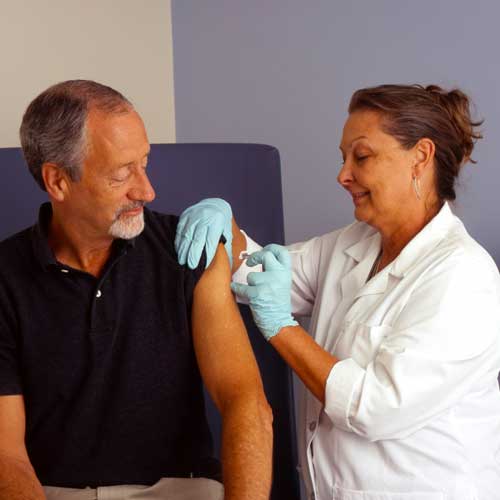 DFW Labor Market Update. A nurse administers an injection into a patient’s arm. Photo Credit: National Cancer Institute on Unsplash [https://unsplash.com/photos/man-in-black-polo-shirt-holding-woman-in-white-button-up-shirt-6FabKijVwAU]