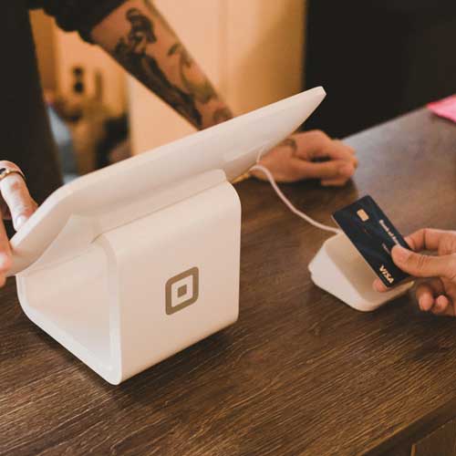 DFW Labor Market Update. A cash register processing a credit card payment. Photo Credit: 2019 Clay Banks on Unsplash [https://unsplash.com/photos/person-holding-white-pos-machine-E2HgkL3LaFE]