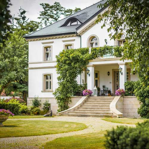 The Connection. A white stone house with a large yard. Photo Credit: 2020 Bartłomiej Balicki on Unsplash [https://unsplash.com/photos/white-concrete-house-near-green-trees-during-daytime-7icYxbgI9qk]